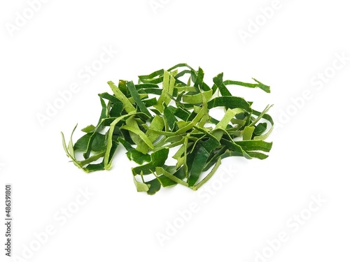 Fresh organic kaffir lime leaves, no chemicals, cut into pieces as a cooking ingredient.  Green leaves, placed on a white background.