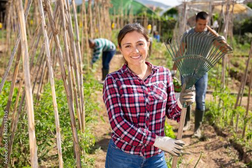 Portrait of latino female farmer in his garden with rake