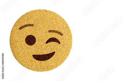 winking face,round cork coaster on a white background