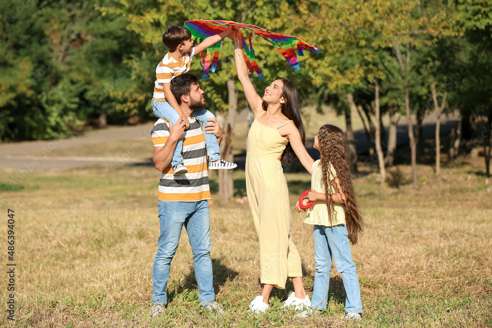 Fototapeta premium Happy couple with little children and kite outdoors