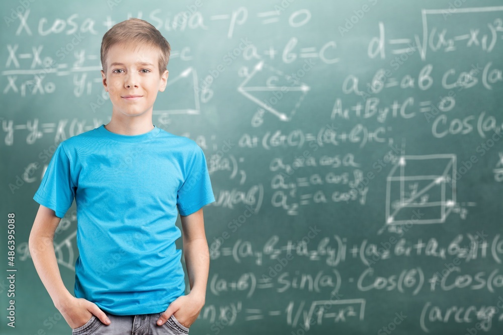 Happy cheerful proud confident smiling cute student standing posing in classroom on chalkboard blackboard with formulas background. Happy cheerful proud confident smiling cute student standing posing in classroom on chalkboard blackboard with formulas background.