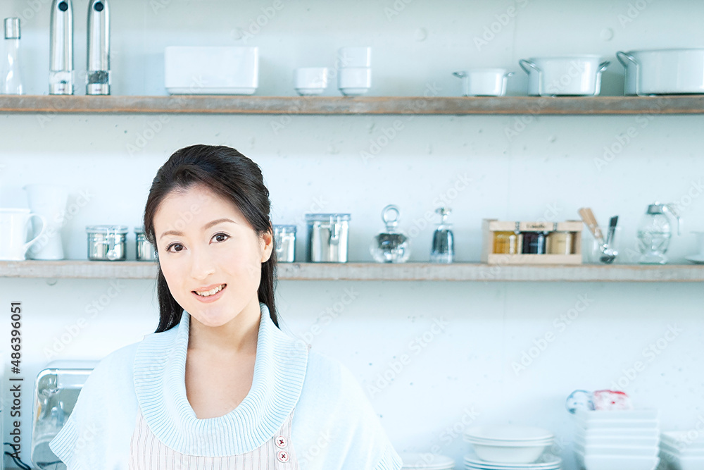 キッチンに立つ笑顔の主婦