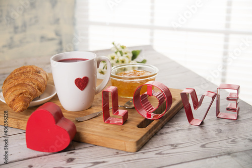 Valentine's day croissant, coffee and lheart on the table photo