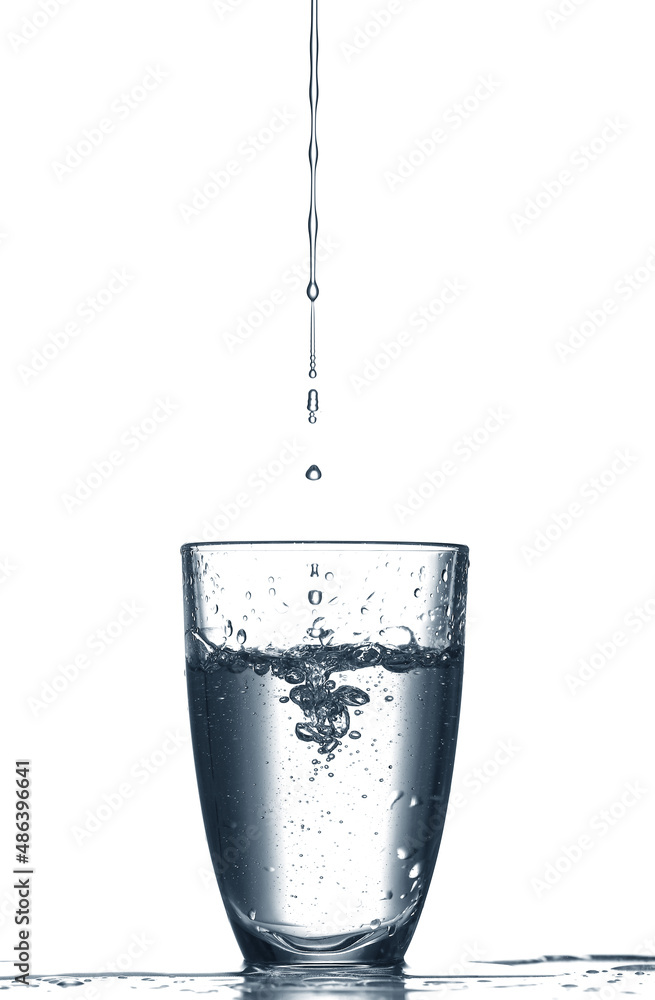 Pouring of clear water in glass isolated on white Pouring of clear water in glass isolated on white