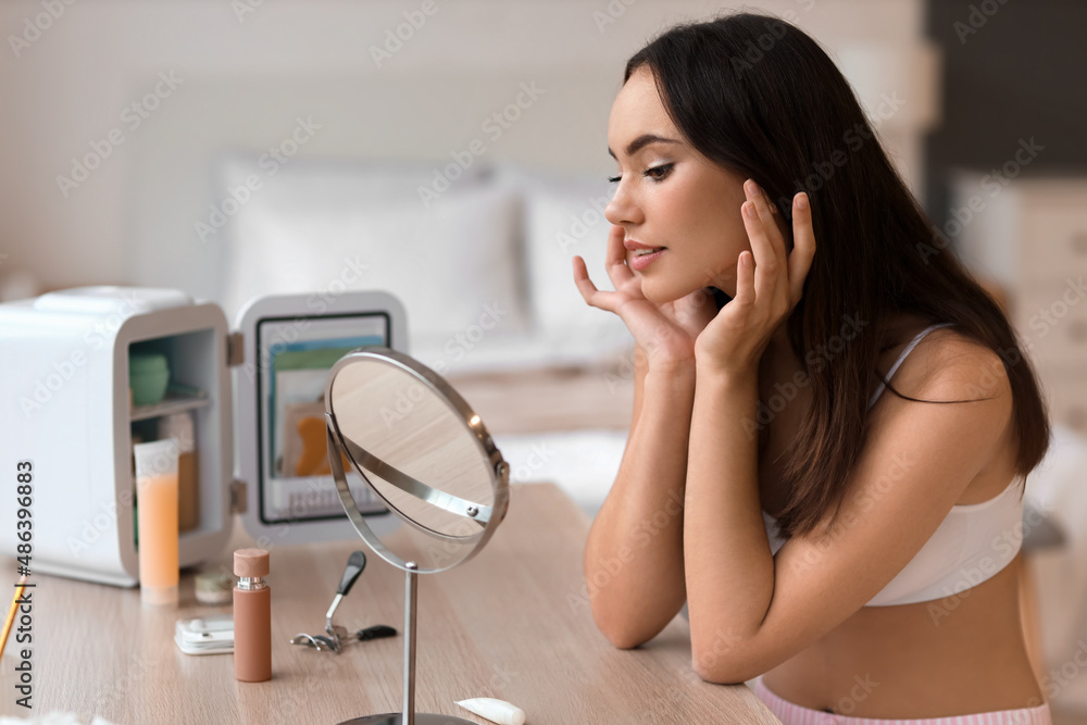 Beautiful young woman sitting at dressing table at home Beautiful young woman sitting at dressing table at home