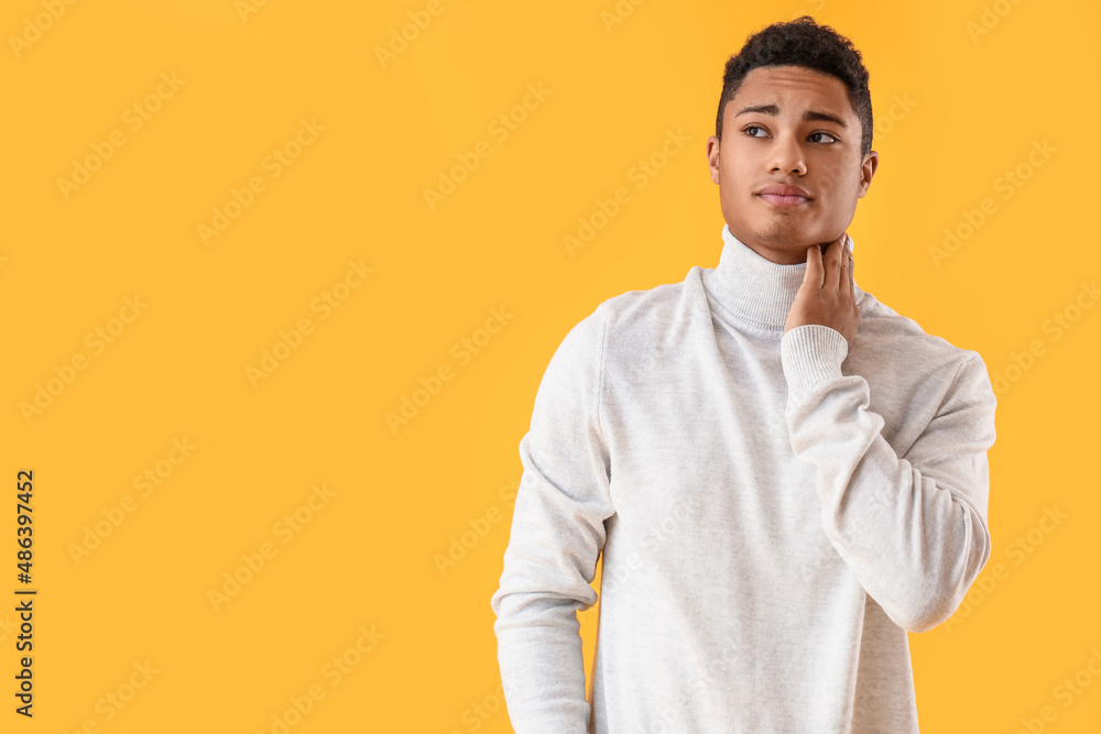 Ill African-American guy with sore throat on color background Ill African-American guy with sore throat on color background