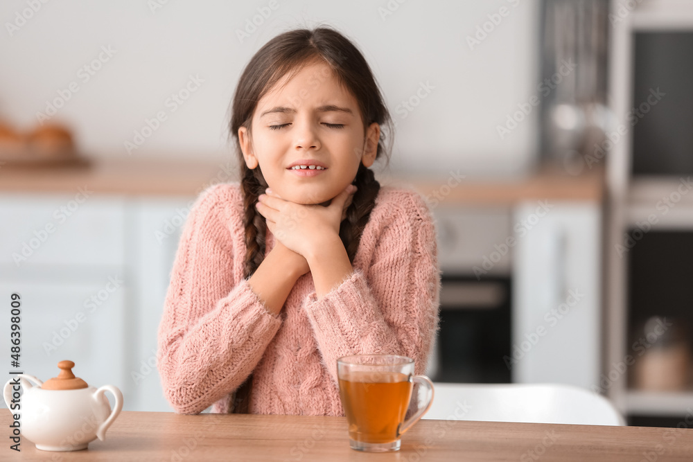 Little girl suffering from sore throat in kitchen Little girl suffering from sore throat in kitchen