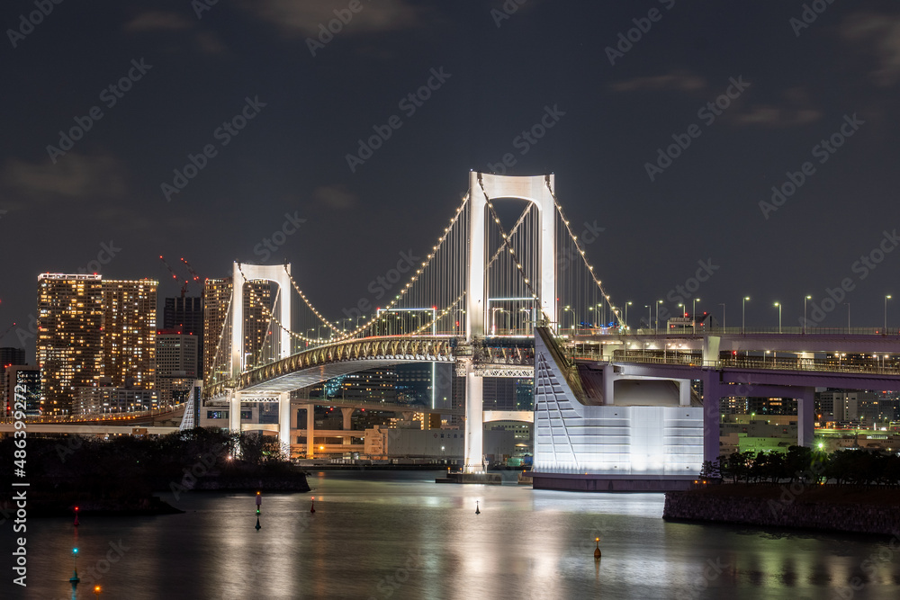 Fototapeta premium Rainbow bridge in Odaiba, with Tokyo city lights in the background