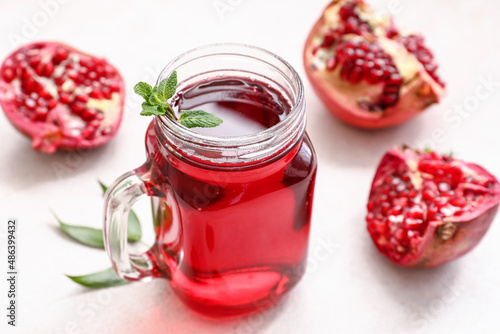Mason jar of delicious pomegranate juice and fresh fruits on white background