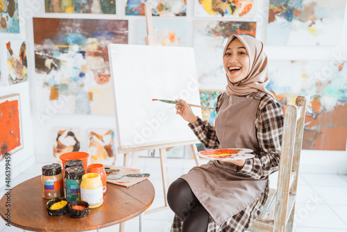 muslim asian female artist painting on canvas