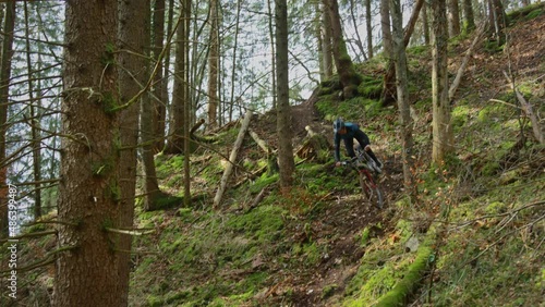 A mountain biker rides down an extremely exposed trail in the forest photo