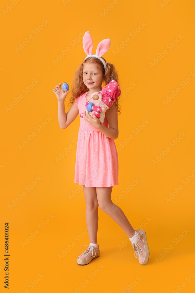 Funny little girl with bunny ears, egg and toy on color background. Easter celebration Funny little girl with bunny ears, egg and toy on color background. Easter celebration