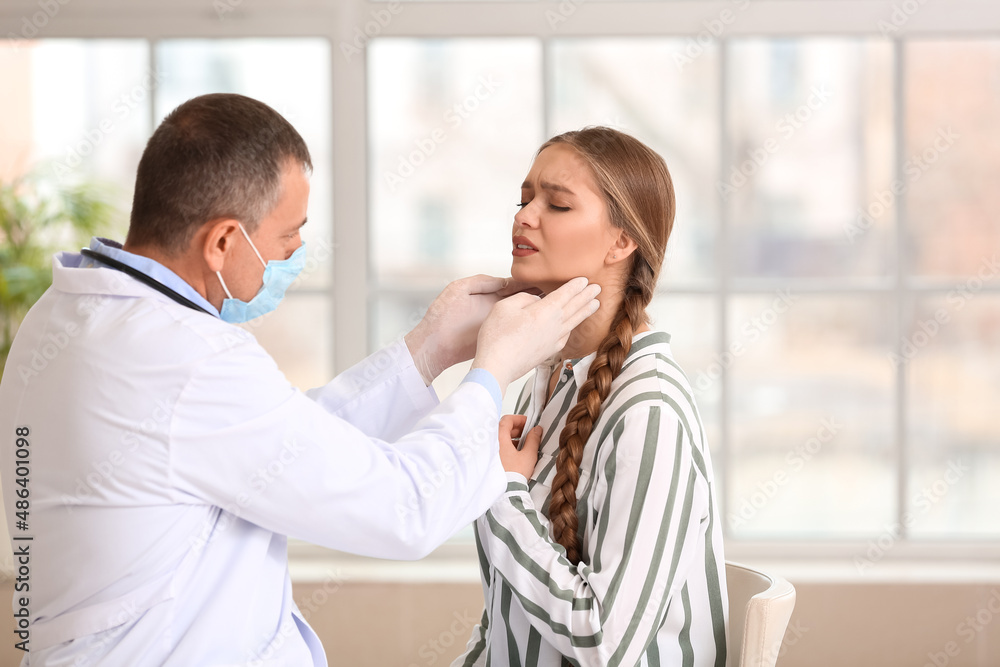Doctor examining woman's neck in clinic Doctor examining woman's neck in clinic