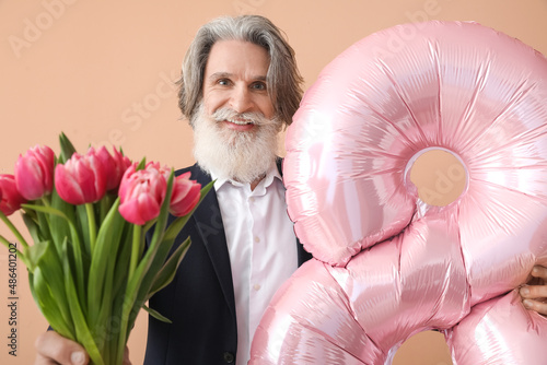 Senior man holding balloon ...