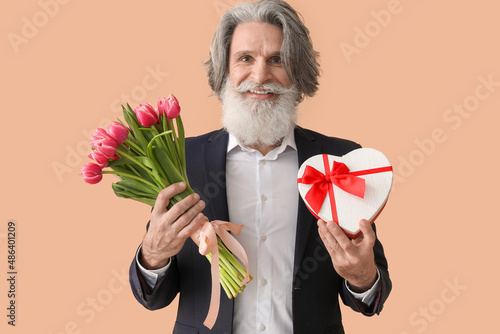 Senior man holding gift box...