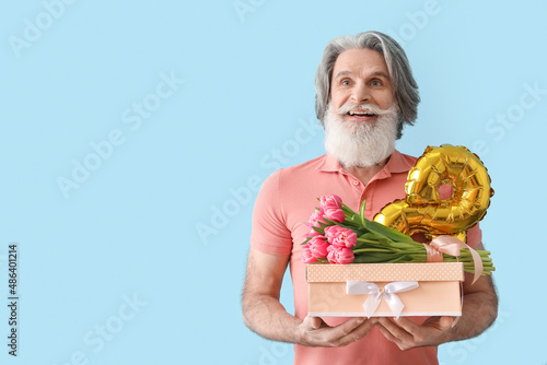 Senior man holding gift box...