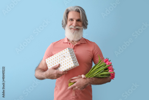 Senior man holding gift box...