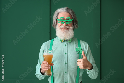 Senior man with glass of be...