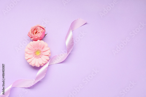 Composition with beautiful flowers and ribbon on color background. International Women's Day celebration