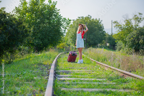 a man is walking on the railroad with a suitcase