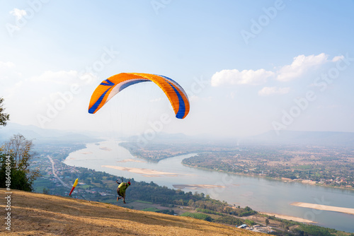 Paraglider flying on Mekong River at Pha Tak Suea, Nongkhai Thailand.