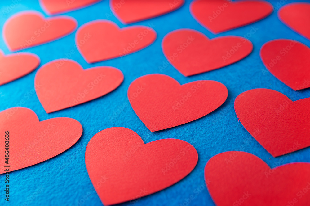 Paper cut red hearts shape on blue textured background with copy space. Concept image. Valentine's day, mother's day, birthday greeting cards, invitation, celebration