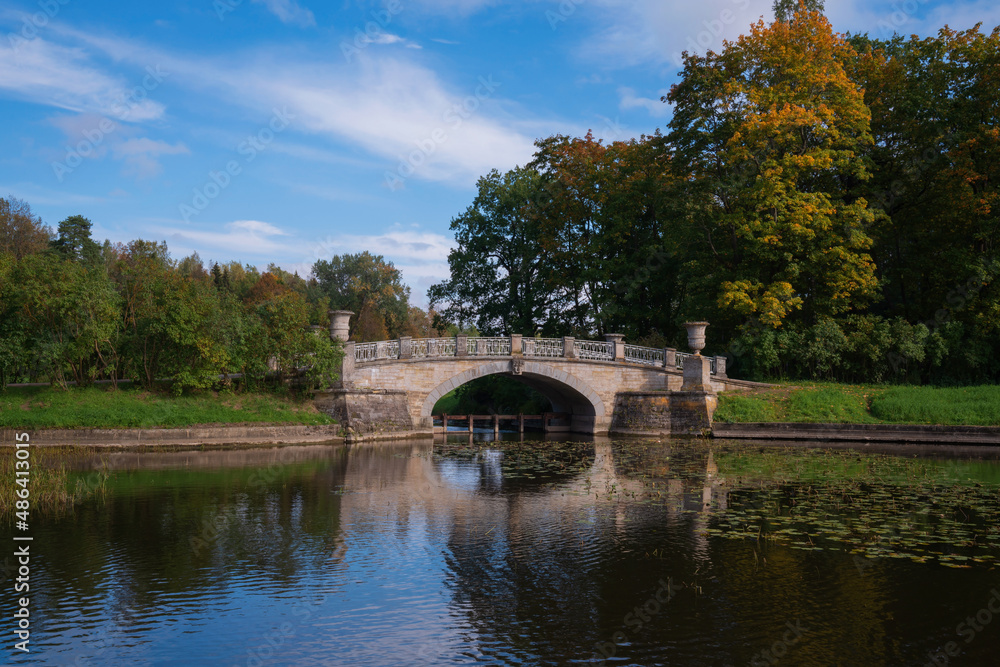 View of the Slavyanka River and the Viscontiev Bridge in the Pavlovsk Palace and Park Complex on a sunny autumn day, Pavlovsk, Saint Petersburg, Russia View of the Slavyanka River and the Viscontiev Bridge in the Pavlovsk Palace and Park Complex on a sunny autumn day, Pavlovsk, Saint Petersburg, Russia