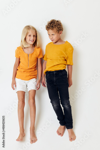 Cute preschool kids in yellow t-shirts standing side by side childhood emotions unaltered