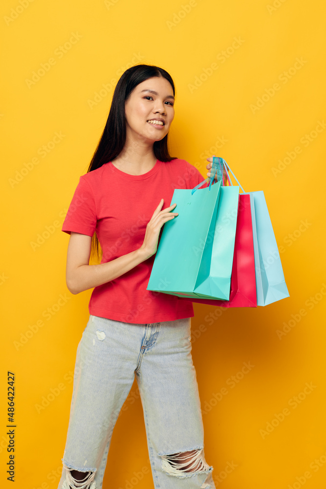 pretty brunette with colorful bags posing shopping fun yellow background unaltered