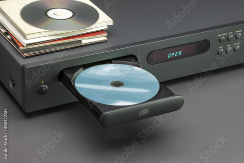 CD player with open tray, close up. Disc, envelopes on the cover of the player.