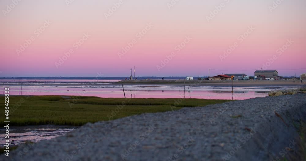 Beautiful purple sunset sky over small waterfront fishing oyster docks town France Beautiful purple sunset sky over small waterfront fishing oyster docks town France