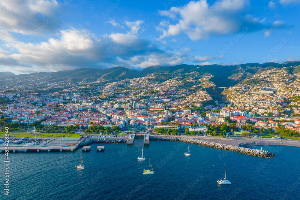 Aerial drone view of Funchal city center and port panorama in Madeira island in the evening. It's Portugal's Autonomous Region and is located in Atlantic ocean