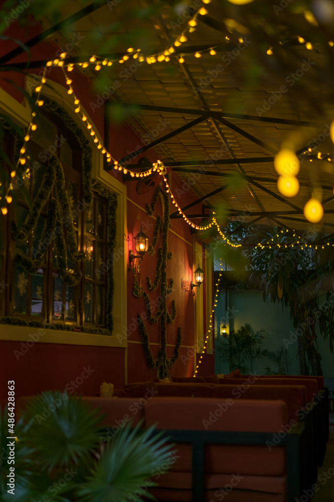 Christmas decorations in the bar. Yellow garlands on the walls. Happy new year. Restaurant interior Christmas lights, lamps. High quality photo
