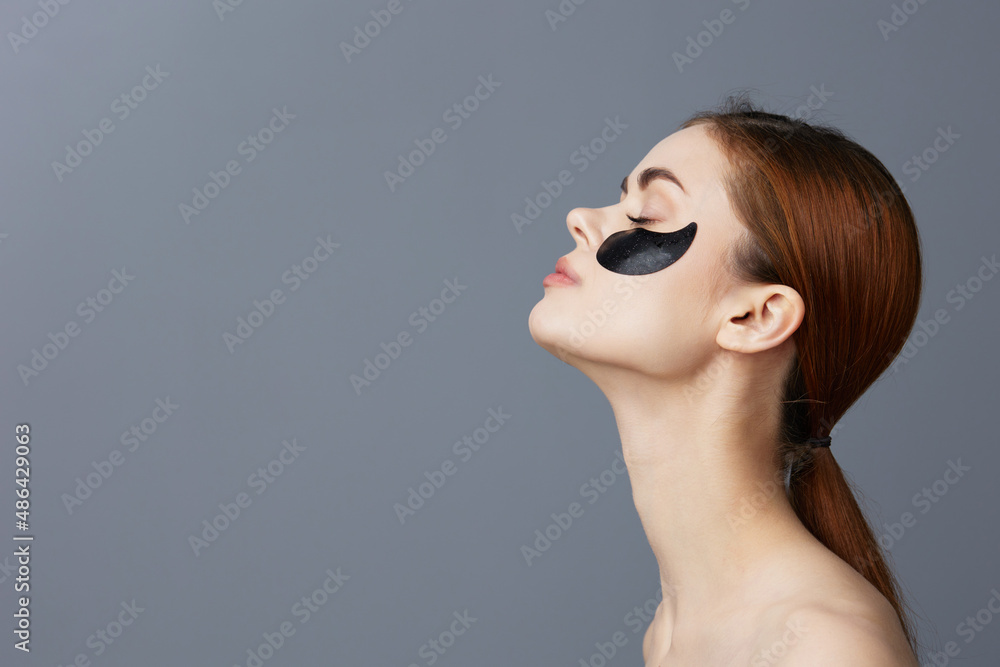 woman eye patches on face bare shoulders skin care isolated background woman eye patches on face bare shoulders skin care isolated background