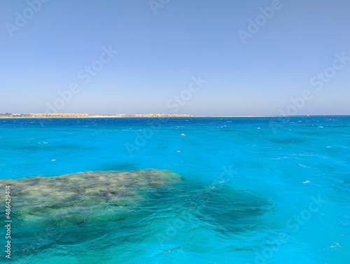 Beautiful view of the azure red sea and coral reef against the blue sky. Copy space. Hurghada, Egypt.