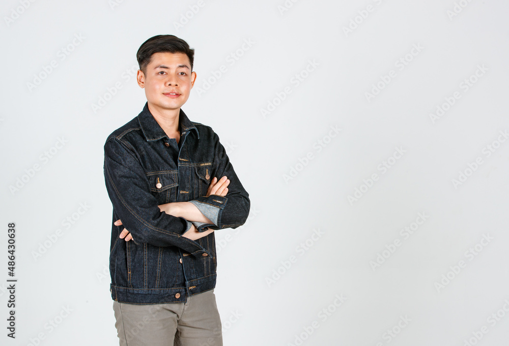 Portrait studio shot Asian young confident handsome cool short hair male hipster model wearing casual street wears denim jeans jacket standing crossed arms smiling look at camera on gray background Portrait studio shot Asian young confident handsome cool short hair male hipster model wearing casual street wears denim jeans jacket standing crossed arms smiling look at camera on gray background