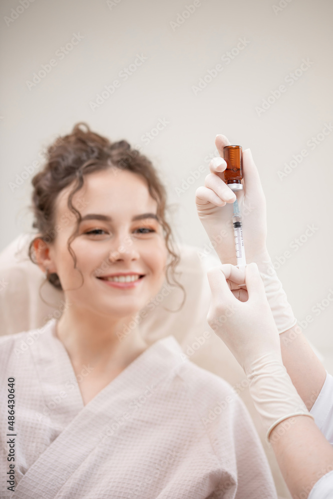 Correction of mimic wrinkles, shape of eyebrows and lips in young curly woman in beauty salon using filler and syringe Correction of mimic wrinkles, shape of eyebrows and lips in young curly woman in beauty salon using filler and syringe