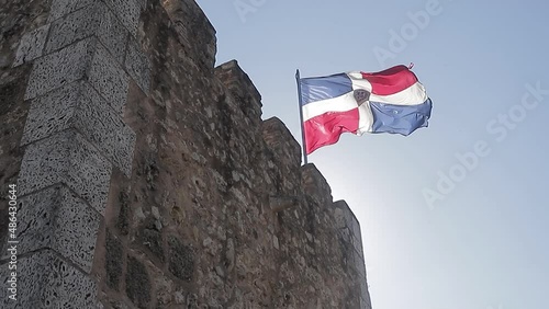 bandera de la república dominicana ondeando en lo alto de la fortaleza de ozama en la zona colonial. photo