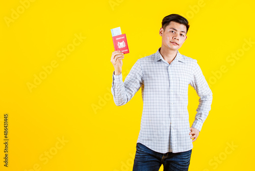 Canvas Print Portrait studio shot of Asian young male traveler model in casual outfit standin