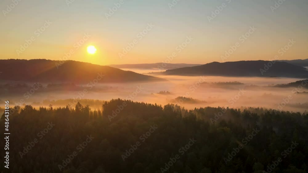 Aerial establishing stunning shot of a sunrise in a mountain valley covered by an autumn fog Aerial establishing stunning shot of a sunrise in a mountain valley covered by an autumn fog