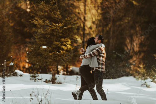 Happy loving couple have fun in winter in forest. Selective focus. photo