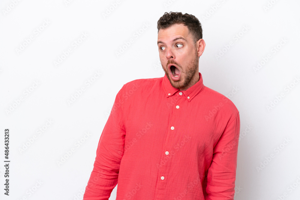 Young Brazilian man isolated on white background doing surprise gesture while looking to the side Young Brazilian man isolated on white background doing surprise gesture while looking to the side