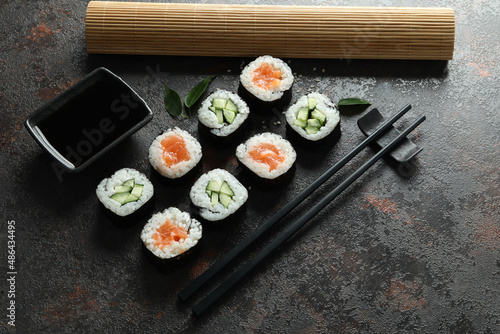Concept of tasty food with maki on dark textured background