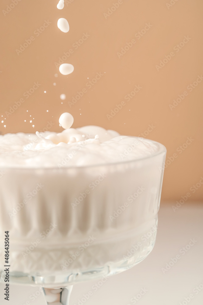 Milk pours into a beautiful crystal glass and splashes around. Milk pours into a beautiful crystal glass and splashes around.