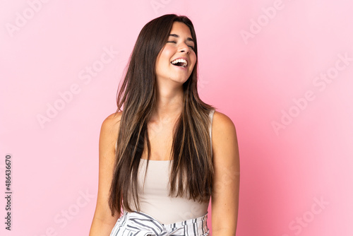 Young brazilian woman isolated on pink background laughing