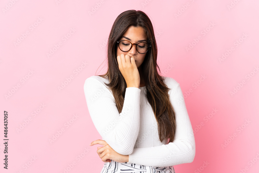 Young brazilian woman isolated on pink background having doubts Young brazilian woman isolated on pink background having doubts