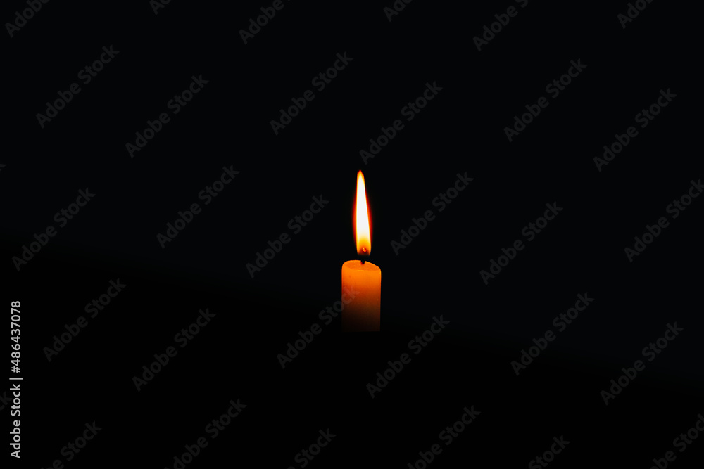 Fototapeta premium glowing candle on the black background
