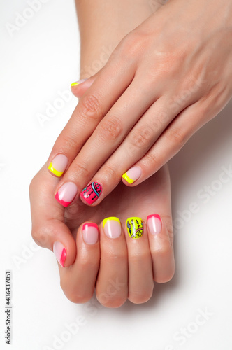 Bright, summer nail design. French colored yellow, coral manicure on short square nails close-up on a white background. Painted dream catcher on the ring fingers.