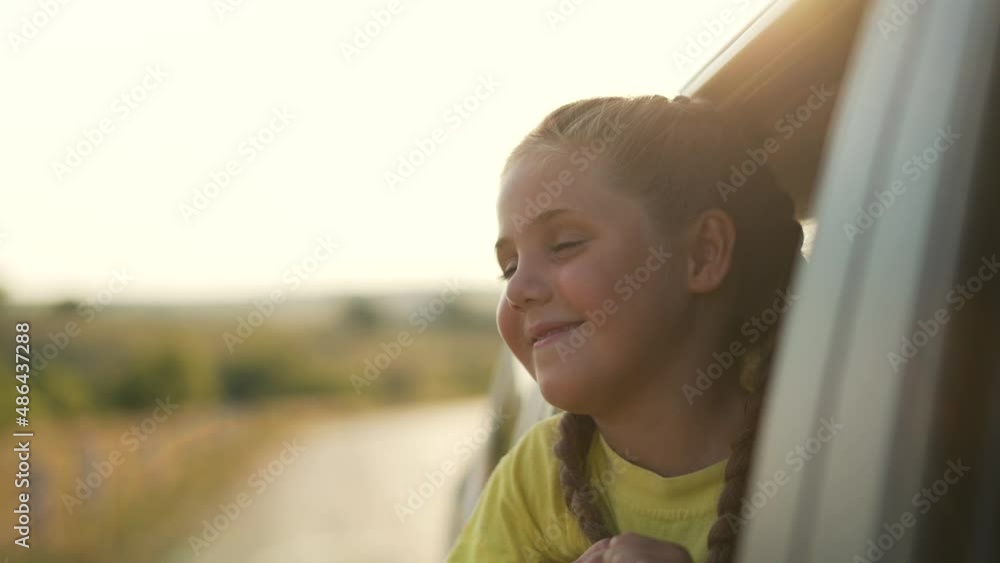 Child girl travel by car. Family vacation concept. Girl thinks about the dream by window. Happy road trip by car. Summer family vacation.Forest road. Travel dream child. Girl in wind in the car window Child girl travel by car. Family vacation concept. Girl thinks about the dream by window. Happy road trip by car. Summer family vacation.Forest road. Travel dream child. Girl in wind in the car window