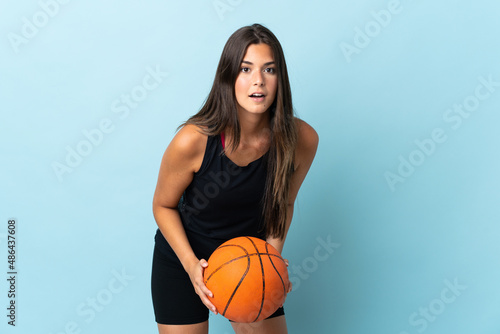 Young brazilian girl isolated on blue background playing basketball © luismolinero